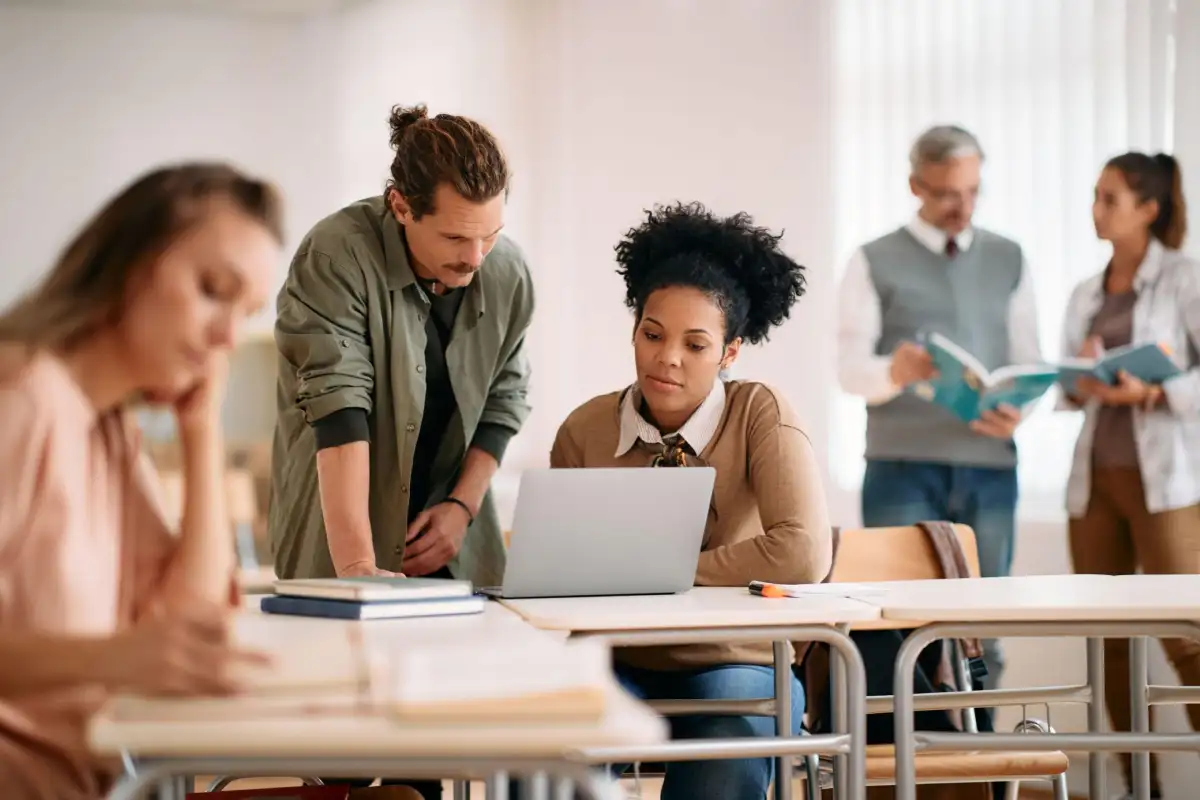 Plusieurs personne dans un local de formation avec deux sur un ordinateur